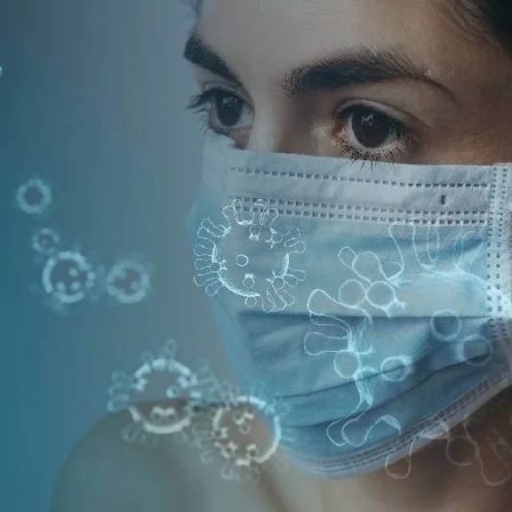Ein Bild von einer Frau die eine blaue Mundschutz Maske trägt, auf dem Bild sind einige Viren Symbole drauf